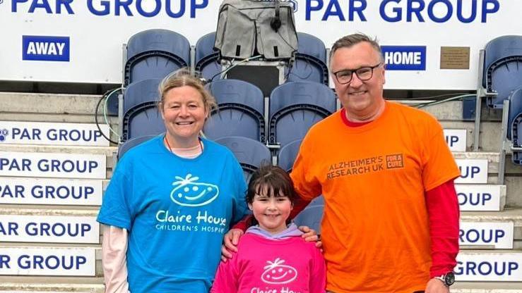 Claire and David with their daughter, Heidi, smiling at the camera