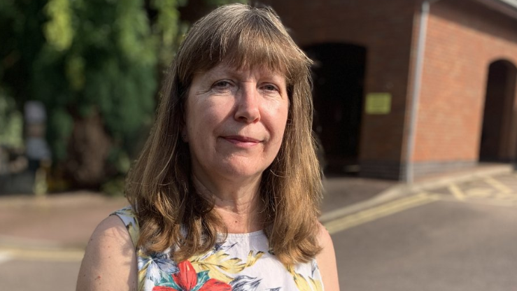 Amanda Ball outside wearing a white flower-patterned top