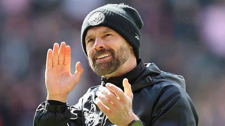 MK Dons boss Paul Warne claps the club's supporters