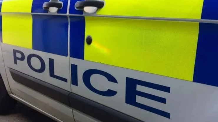 The side of a police car with police written in blue letters