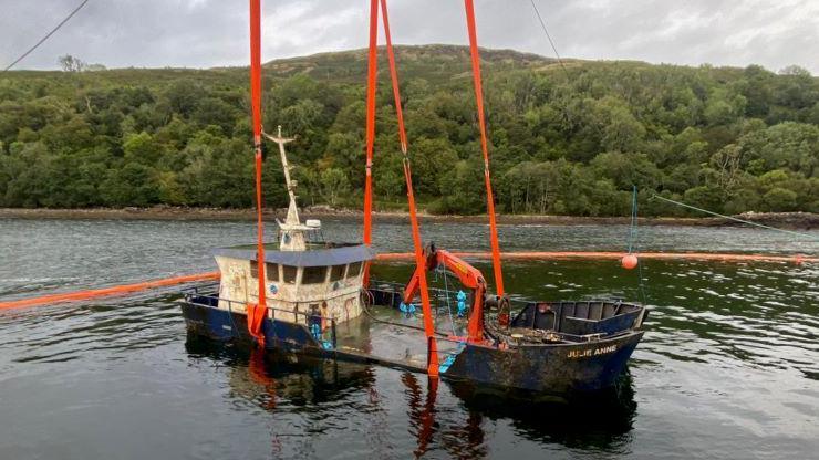 Landing craft Julie Anne being lifted by straps using a crane from the site of its sinking