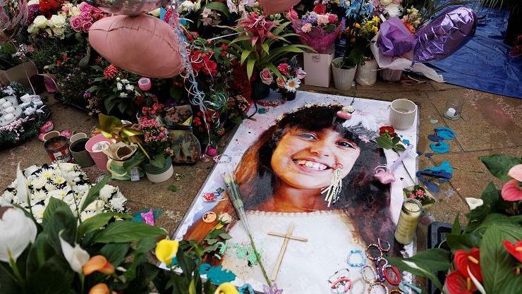 Floral tributes, balloons and friendship bracelets at a Southport tribute featuring an image of Alice