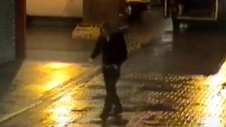 A blurred image of a hooded man walking through Leicester city centre on a dark January morning.