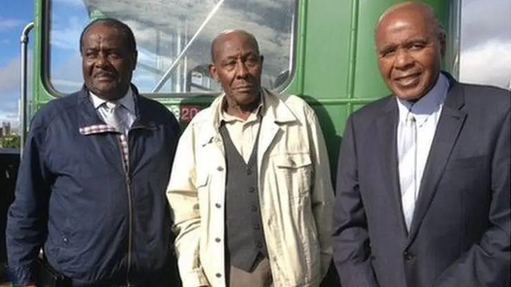 Guy Reid-Bailey, Roy Hackett and Dr Paul Stephenson OBE stood next to an old green bus.