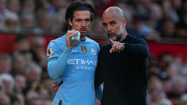 Manchester City coach Pep Guardiola speaks to Jack Grealish on the touchline