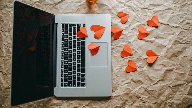 Laptop with red paper hearts scattered around it