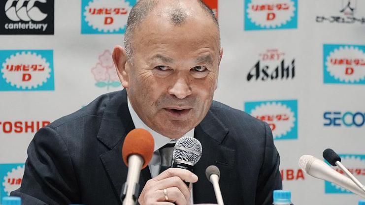 Eddie Jones speaks into a microphone