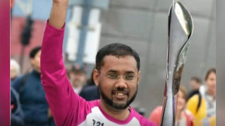 Mohammed smiling and carrying the Commonwealth Games baton