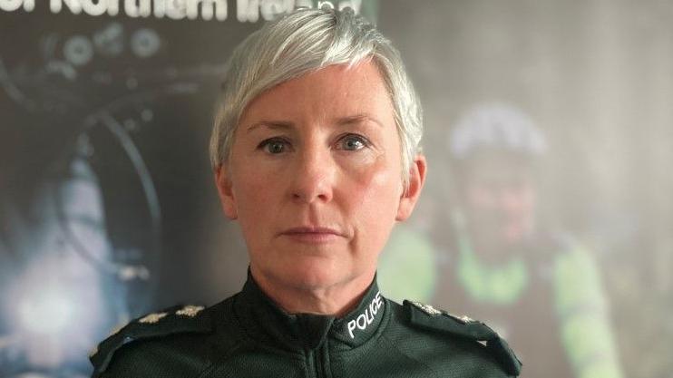 Ch Insp Yvonne McManus wearing a police uniform. 
She has short hair and is standing in front of police background