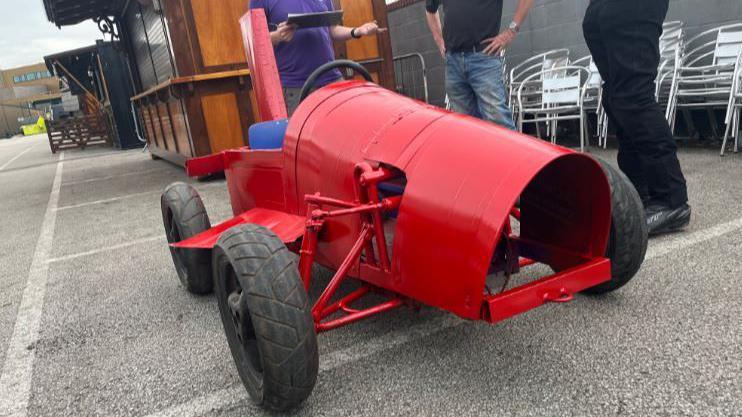 A red single-seater soapbox with four black wheels