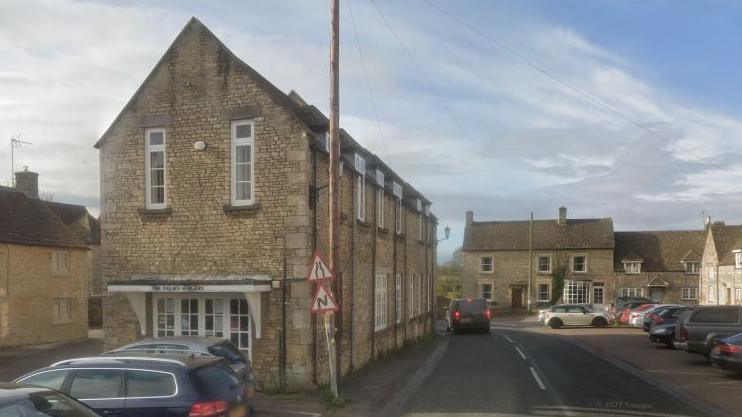 A view of the old Cotswold stone building - which is more like a house - beside the road