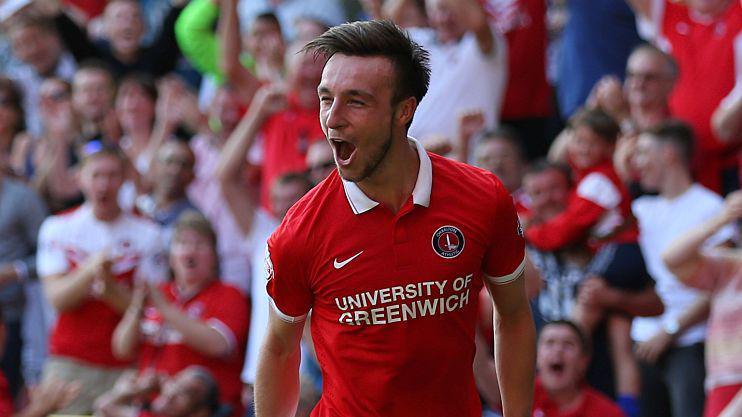 A man with short brown hair celebrates as he runs towards the crowd