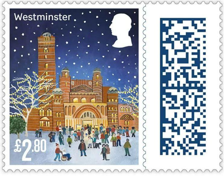 An illustrated version of Westminster Cathedral on a 1st class stamp. The building is lit up and the trees outside it have lights strung on them. People are gathering in the snow as a person pushes someone using a wheelchair. 