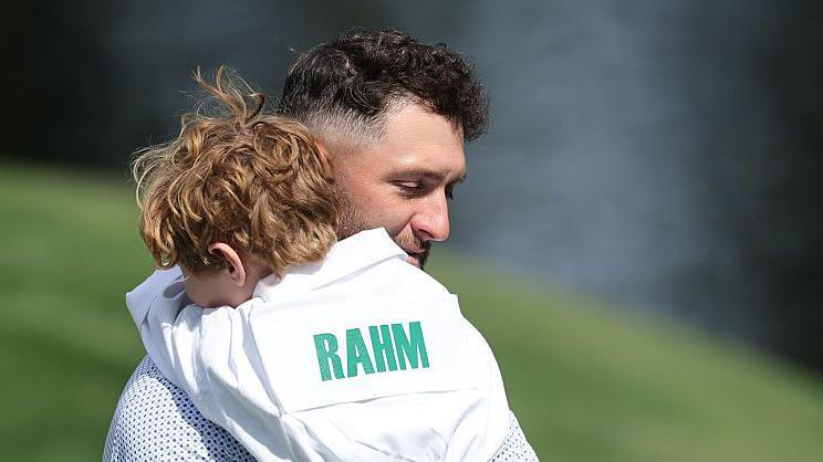 Jon Rahm carries his son Kepa