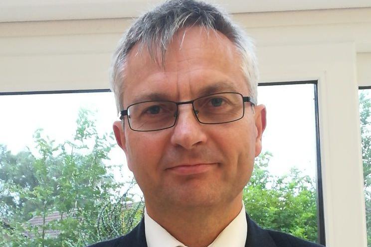 Interim HM Chief Inspector of Prisons for Scotland, Stephen Sandham a man with grey hair and glasses in a suit jacket and a blue tie with a spotty pattern and white shirt