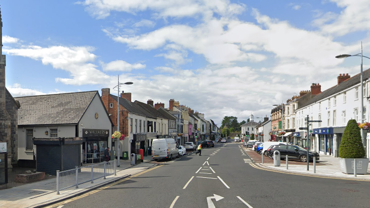 A wide view of a church and shops on High Street in Antrim 