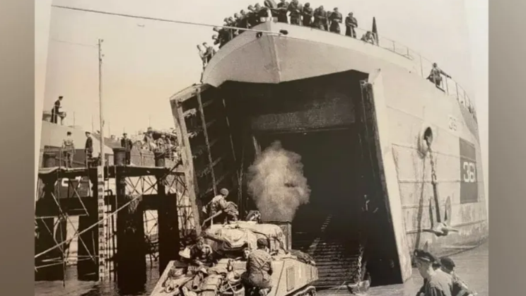 A landing vessel unloading a tank on to the beach during the Normandy invasion 