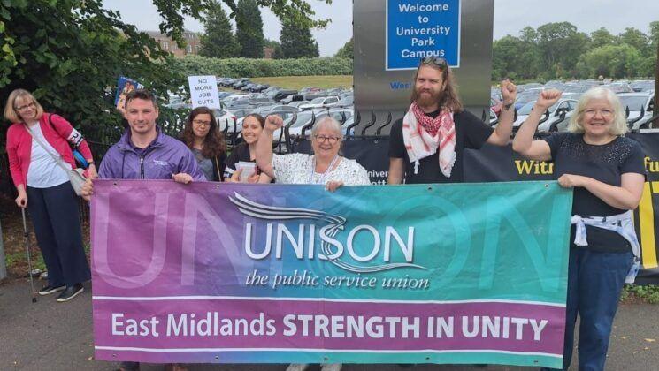 A picket line with workers holding a Unison banner