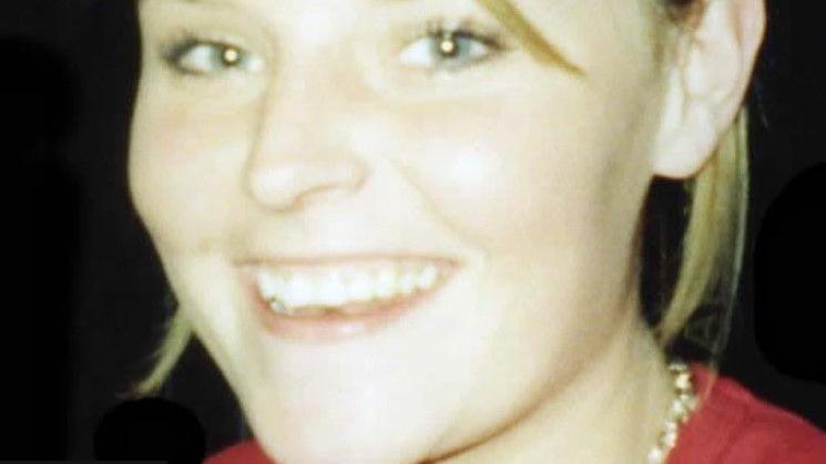 A photo of Lisa Dorrian, she is wearing a red top and gold necklace