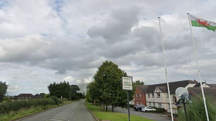 Google image of the road with the hotel to the right and flagpoles with Welsh flag at the entrance 