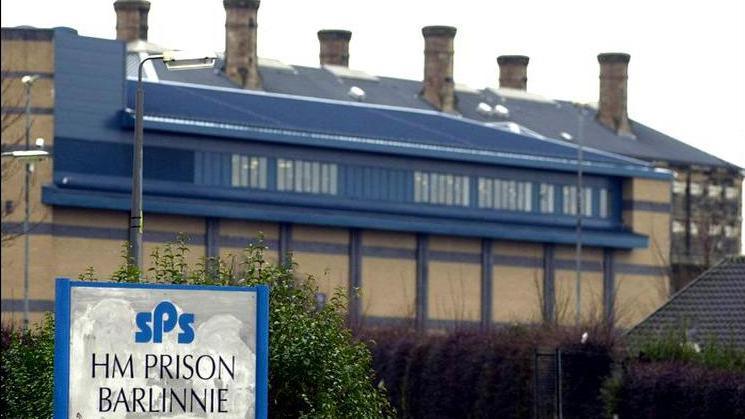 The outside of Barlinnie prison, a brick building with a blue roof and six chimneys