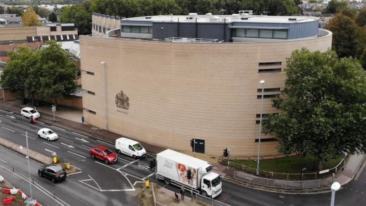 An aerial view of the Cambridge Crown Court building. Traffic can be see on a nearby road.