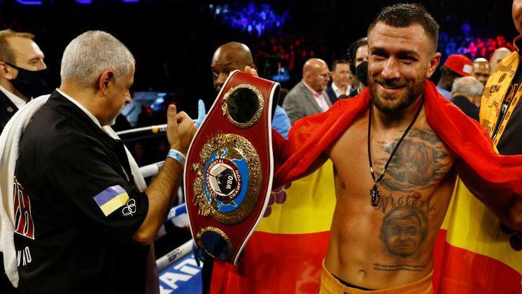 Vasiliy Lomachenko celebrates with Ukrainian flag and the WBO intercontinental lightweight title