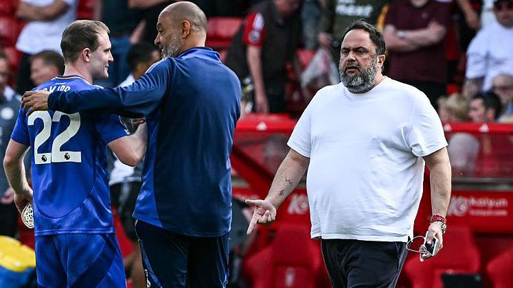 Evangelos Marinakis walks towards Nuno Espirito Santo on the pitch