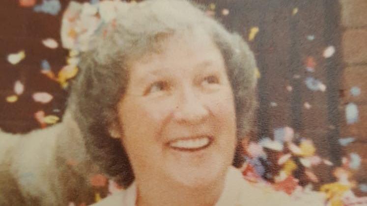 June Westhead is smiling on her wedding day as colourful confetti is thrown into the air.