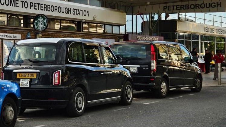 Row of black cabs parked outside the Peterborough train station 