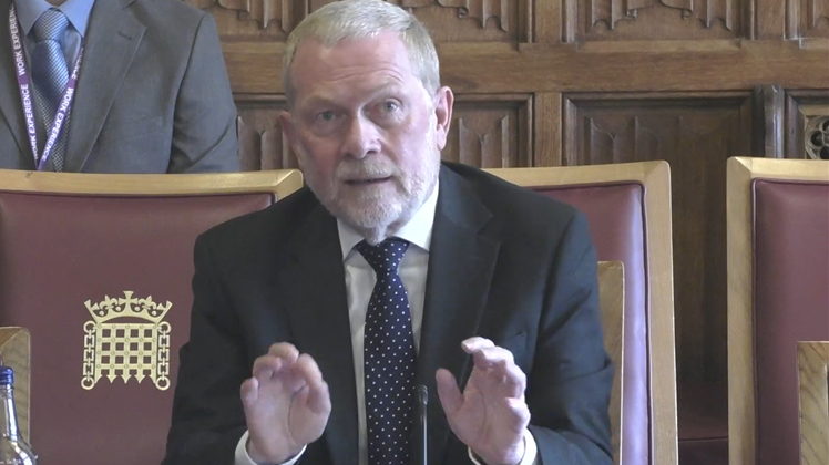 David Bolt in front of the Justice and Home Affairs Committee, wearing a black suit and blue tie.