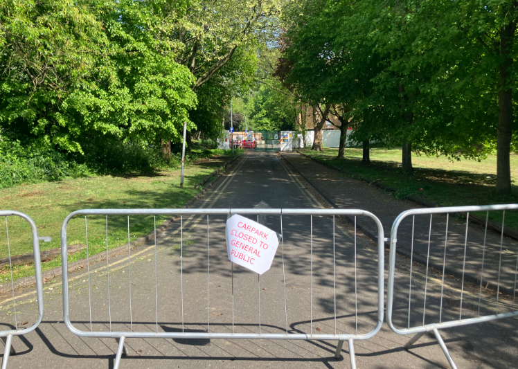 Metal grills on the road with a car park closed paper sign