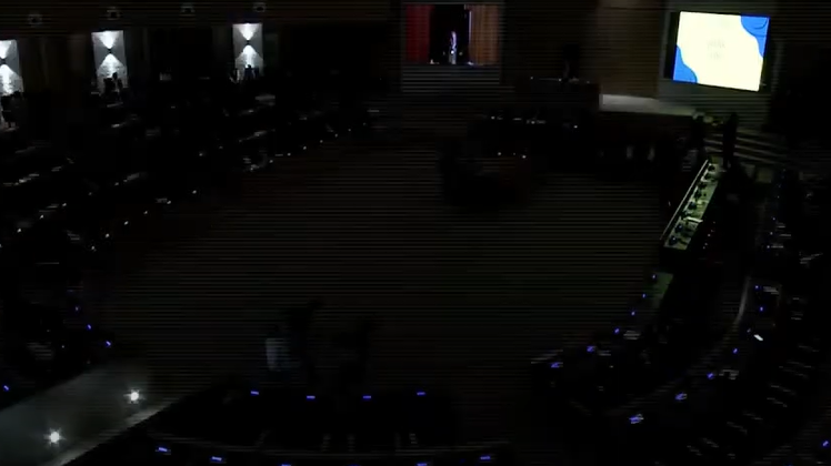 Very limited lighting as members of parliaments sit in darkness.