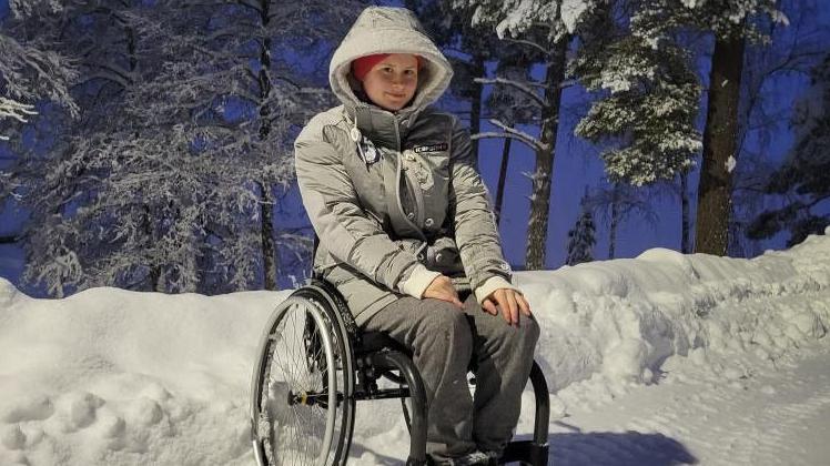 Anna Hontar sits in front of a snowdrift in Finland