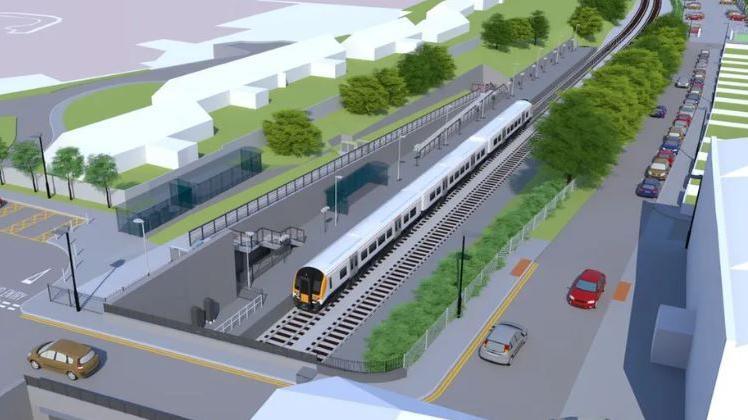 A computer generated aerial image of what the train station at Pill would look like. There are lots of green spaces and trees surrounding the railway line, with a large car park and green roundabout