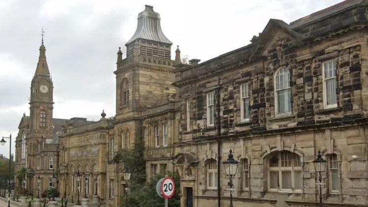 An outside show of Sefton Town Hall with a clock tower to the left