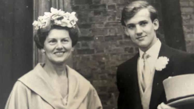 Black and white image of woman with flowers in her hair and man on a wedding day