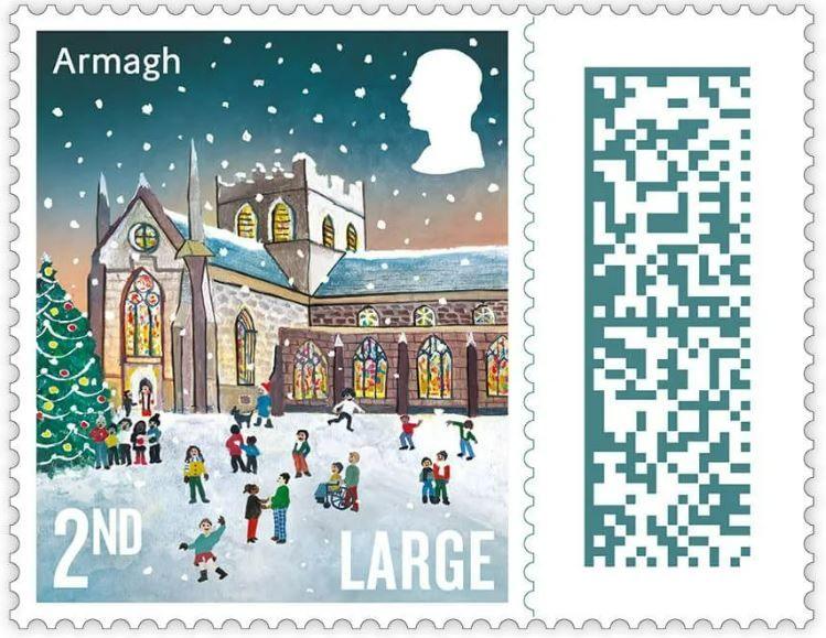 An illustrated version of St Patrick's Cathedral on a 2nd class stamp. The church is lit up with a Christmas tree outside it. Children and adults are playing in the snow.