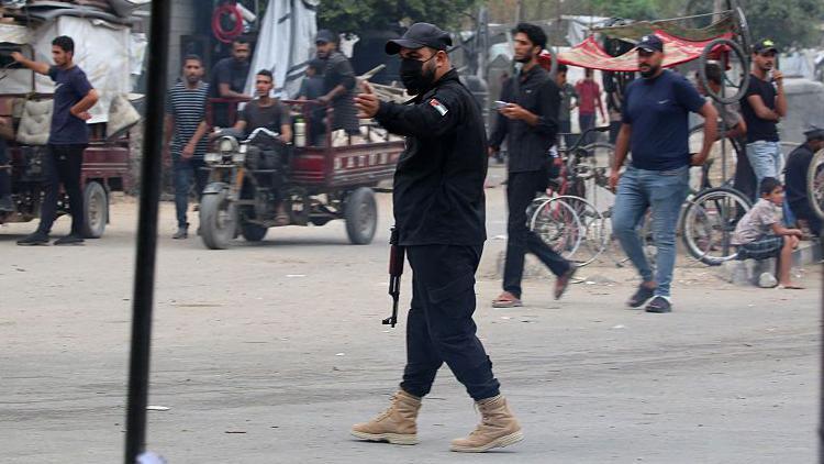 An armed member of the internal security forces loyal to Hamas directs traffic in the central Gaza Strip. Photo: 12 October 2025