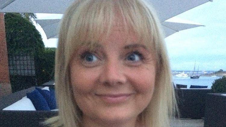 Selfie photograph of Emma Louise Cuthbertson-Smith. She has bright blonde short hair and a full fringe and smiles away from the camera. She has blue eyes.