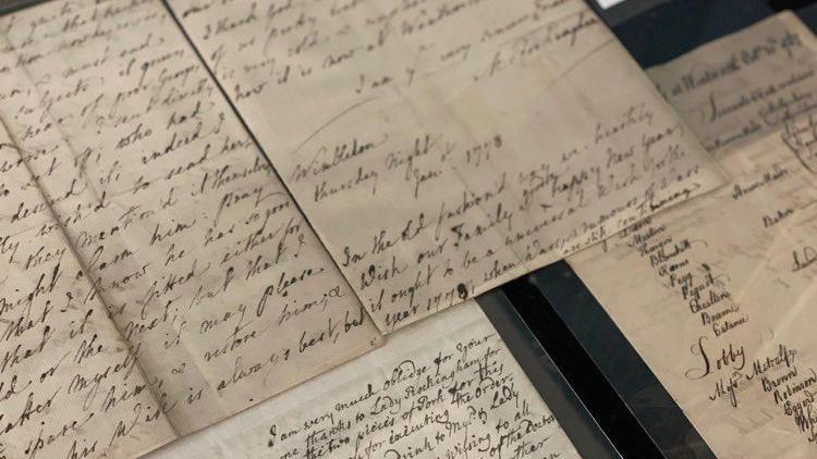 Several letters/papers with ink handwriting on display.