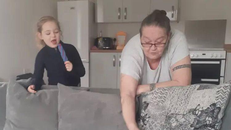 Harper and her grandmother Susan stood above a grey sofa