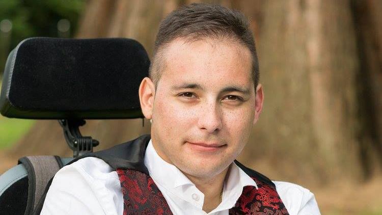 Karl Lee wearing a white shirt and red, printed waistcoat.