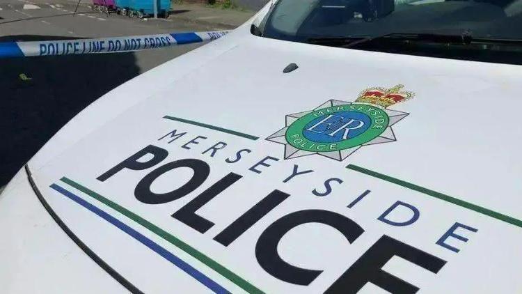 The bonnet of a Merseyside Police patrol car, with the force's badge and name painted onto a white background