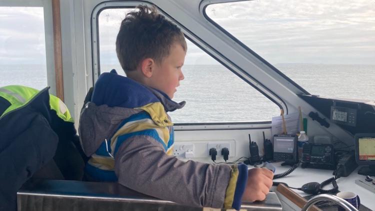 George Foote at the helm of a boat