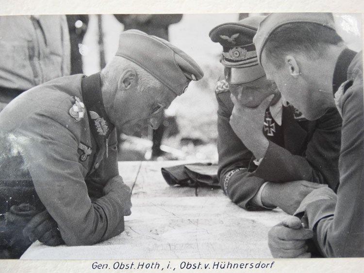 Generals Hoth, left, and von Hünersdorff right, lean intently over a map in full uniform, apparently deep in thought