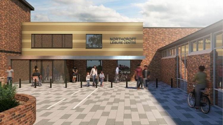 An artist's interpretation of the outside of a leisure centre. There are grey tiles on the floor and the facade of the building is wood and brick. There is a row of black bollards in front of the building. People are milling around outside.