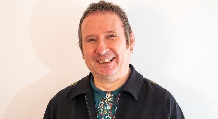 Rad Kerrigan dressed in the Mod style with a "Paul Weller" haircut. He is wearing a paisley pattern shirt and is smiling.