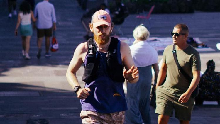 Richard Stennett running in an urban area with people walking in the background