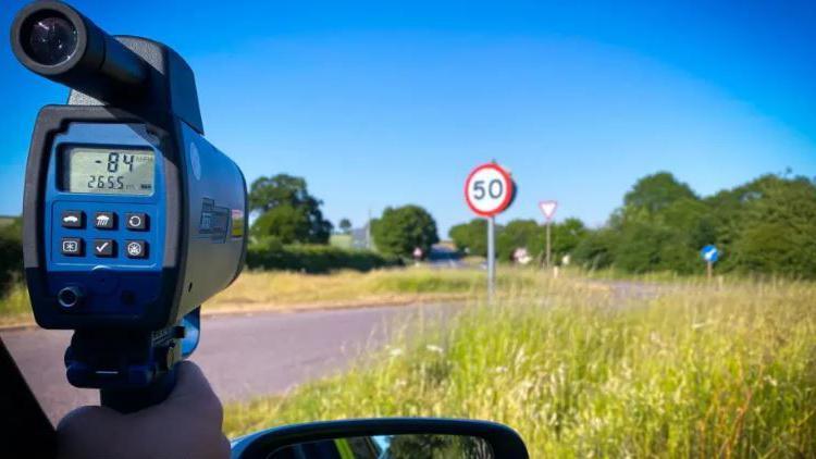 A speeding gun looking at a road 